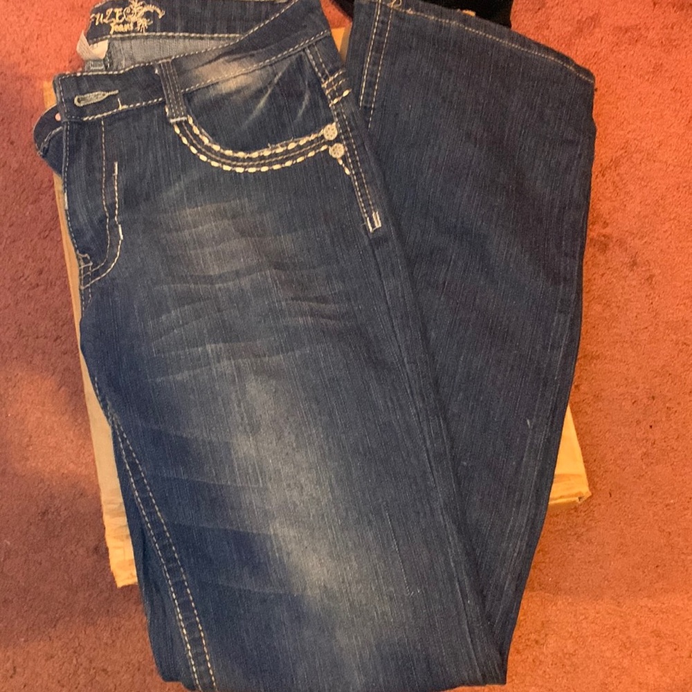Low rise flare dark blue jean, with designs on the front pocket and back.